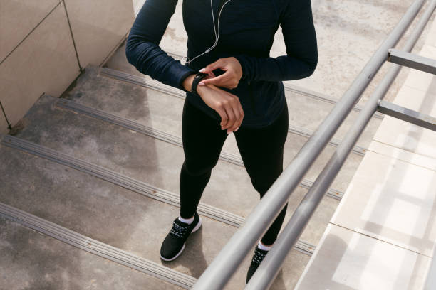 Unrecognizable female using fitness tracker after training Unrecognizable female using fitness tracker after training fitness tracker stock pictures, royalty-free photos & images