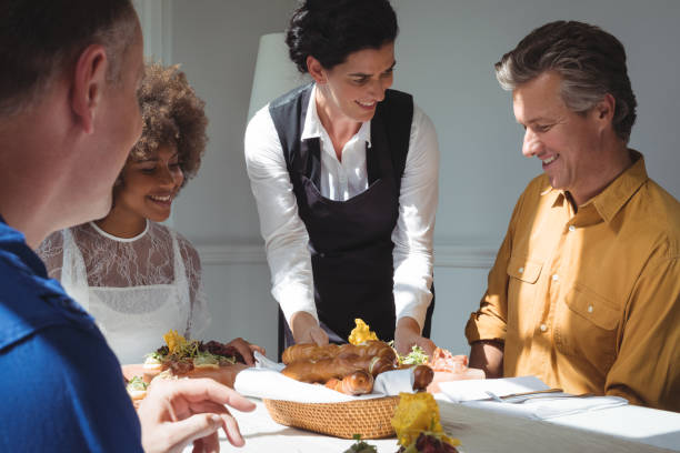 istock Smiling waitress serving food to customers 683432436