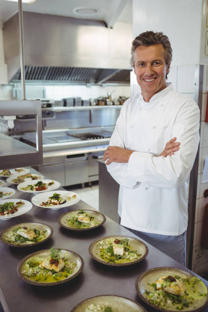 istock Portrait of happy chef with appetizer plates at order station 683448064
