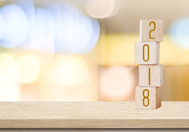 istock Wooden cubes with 2018 on table over blur bokeh background with copy space for text, new year and christmas card background,template 683452320