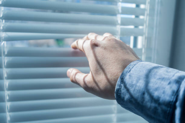 istock Man's hand opens the blinds or jalousie in sunny day. 683461858