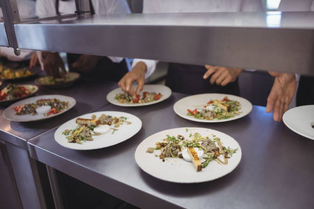 istock Team of chefs garnishing meal on counter 683465888