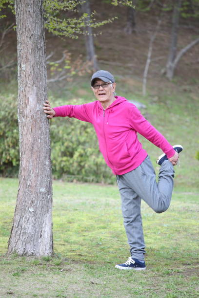 istock senior Japanese man doing standing front thigh stretch 683471984