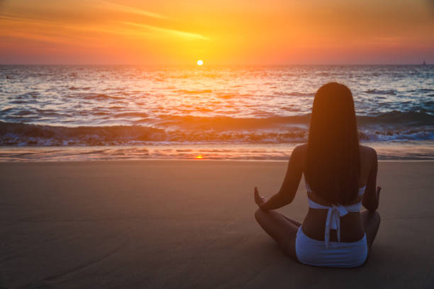 istock Woman yoga on beach at sunset 683475172