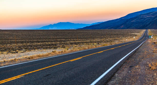 the desert highway in nevada at sunset - asphalt highway desert valley imagens e fotografias de stock