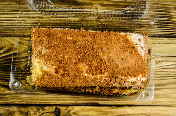 istock Biscuit cake in plastic container on wooden table. Top view 683480348