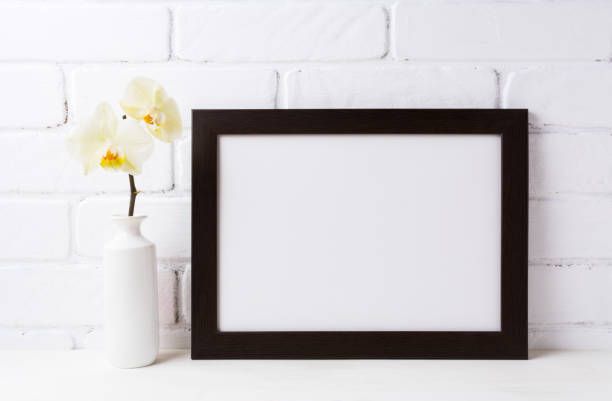 istock Black brown  landscape frame mockup with soft yellow orchid in vase 683499700