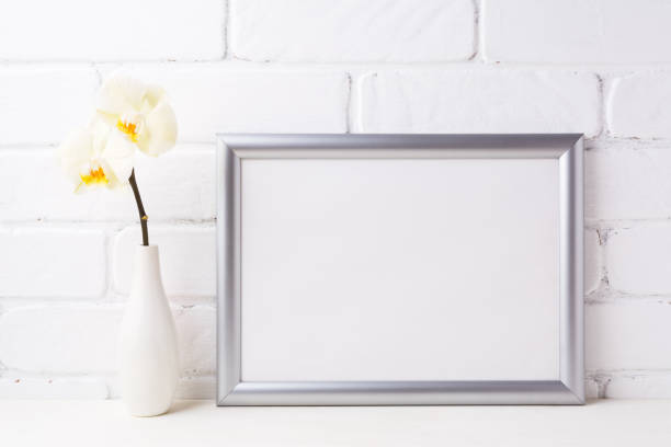 istock Silver landscape frame mockup with soft yellow orchid in vase 683499720
