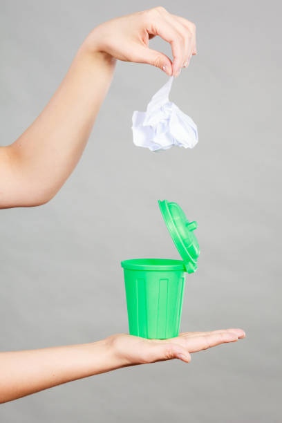 istock Woman putting paper into small trash can 683504108