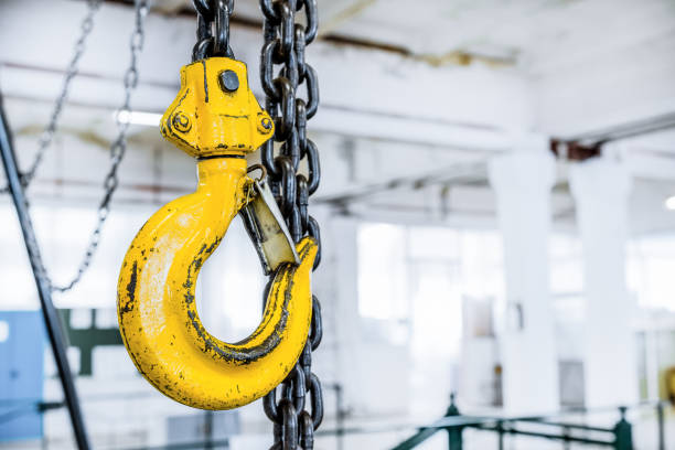 gancio per il sollevamento del carico in acciaio giallo - hoisting crane foto e immagini stock