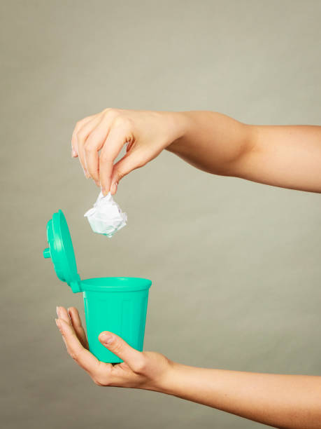 istock Woman putting paper into small trash can 683511780