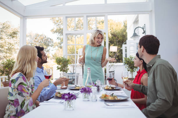 istock Group of friends interacting with each other while having meal together 683512252