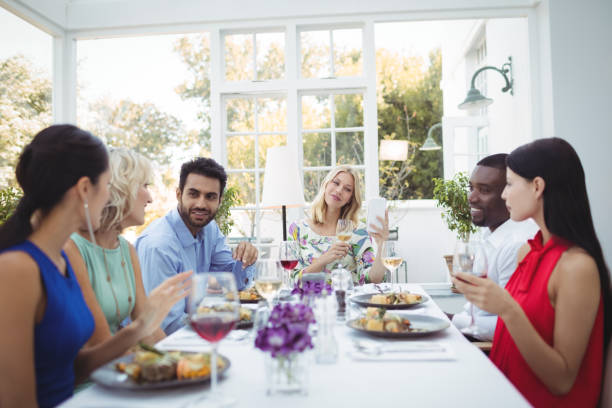 istock Happy friends interacting with each other while having meal 683518188