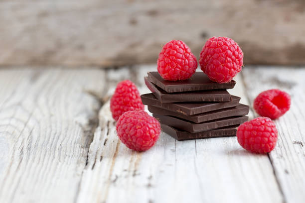 Pilha de chocolate escuro com framboesas frescas - foto de acervo