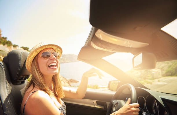 istock Woman laughing while driving fancy car 683524020