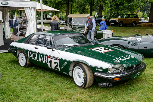 Jaguar XJ-S race car parked in a field. The Jaguar XJ-S or XJS later, is a luxury grand tourer sports car produced by British manufacturer Jaguar from 1976 to 1996. The XJS racing cars were prepared by  Tom Walkinshaw's TWR. The car is on display during 2016 Classic Days at Dyck castle near Juchen in Germany.