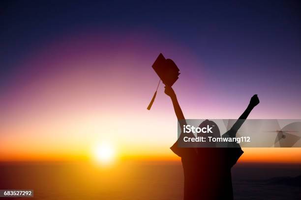 Silhouette Of Student Celebrating Graduation Watching The Sunlight Stock Photo - Download Image Now