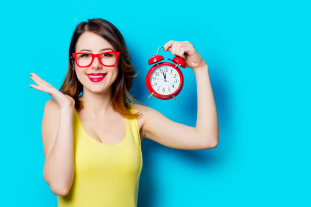 istock young woman with alarm clock 683539262