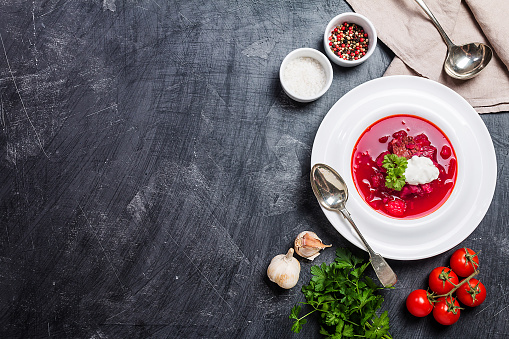 Homemade Russian, Ukrainian and Polish national soup - red borscht made of beetrot, vegetables and meat with sour cream Top view.