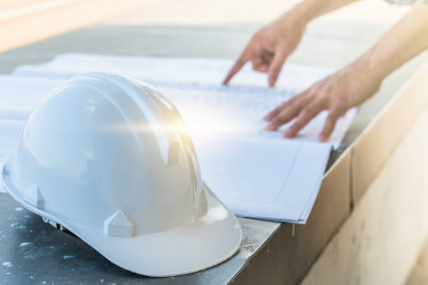 The white helmet with the man verify blueprint for his project