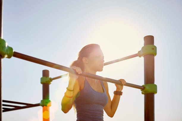 istock Female athlete doing chin-ups on sunny day 683549058