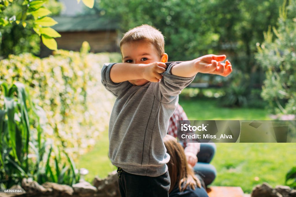 Boy rollng up his sleeves Boy preparing to join friends in play. Fun and play is about to came. Rolled-Up Sleeves Stock Photo