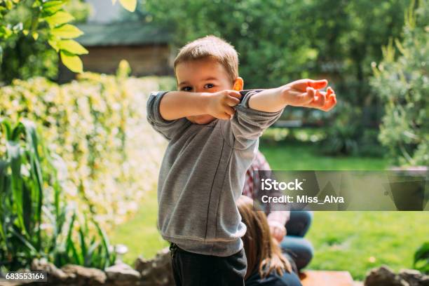 Boy Rollng Up His Sleeves Stock Photo - Download Image Now - Rolled-Up Sleeves, Child, 2-3 Years