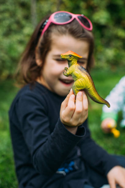 istock Girl in a play with dinosaurus rubber toy 683553822