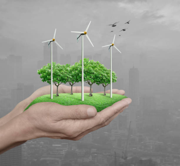 istock Wind turbines, grass and trees in human hands over pollution city, Ecological concept 683558392