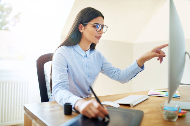 istock Artist pointing at monitor while working at desk 683561058