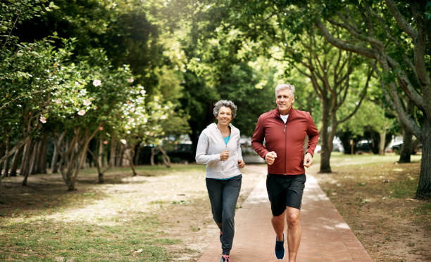 Growing old and getting healthy together Full length shot of a senior couple taking a run through the park common couple men outdoors stock pictures, royalty-free photos & images