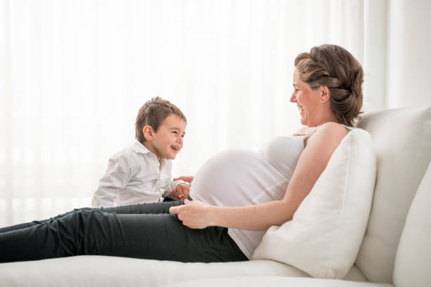 istock pregnant mother playing with her young son 683564640