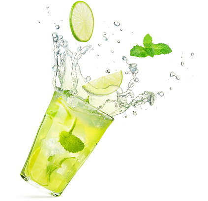 lime and mint falling into a splashing mojito cocktail isolated on white background