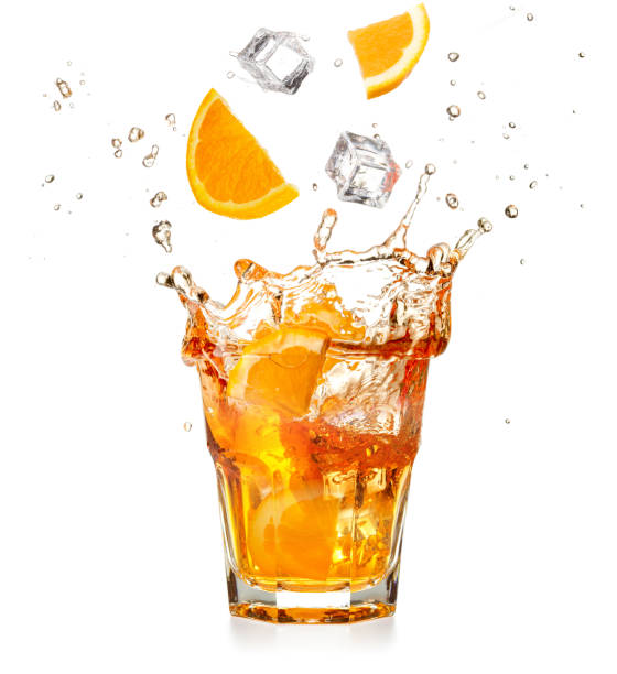 fatias de laranja e cubos de gelo caindo em um coquetel de salpicos - glass water isolated drink - fotografias e filmes do acervo