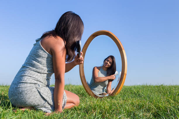 istock Woman combing her hair in mirror outside 683568200