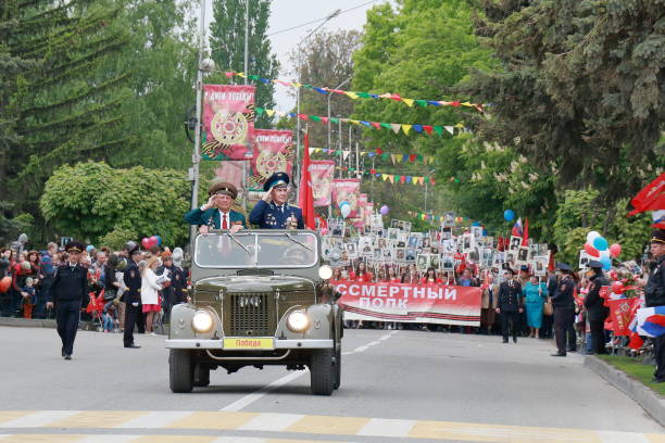 Old UAZ car with war veterans. Pyatigorsk, Russia Pyatigorsk, Russia - May 9, 2017: A rarity off-road UAZ car with veterans is headed by the column Immortal Regiment. Participants column Immortal Regiment bear plaques with the image of his relatives died in the battle jeep 4x4 off road vehicle world war ii stock pictures, royalty-free photos & images