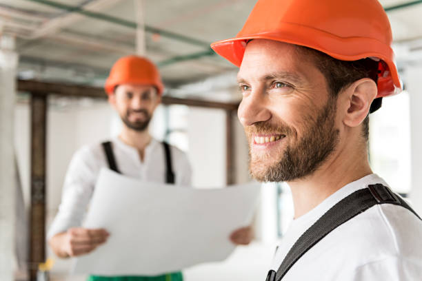 constructor sonriente hilarante en la habitación no lista - unready fotografías e imágenes de stock