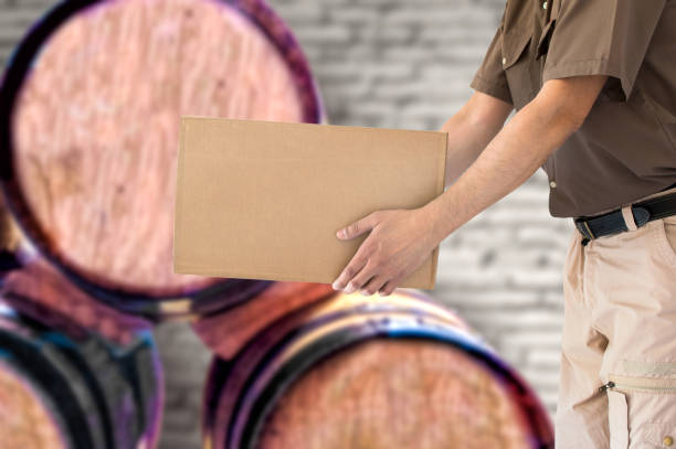 Wine transportation Man holding cardboard box of wine bottles at wine cellar wine shipping stock pictures, royalty-free photos & images