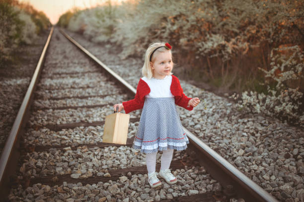 Cute girl with suitcase on railway