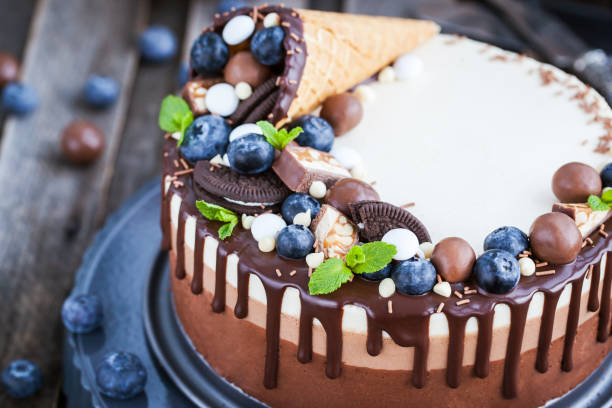 istock Delicious three chocolate mousse cake decorated with waffle cone, fresh blueberry, mint, candies 683583774