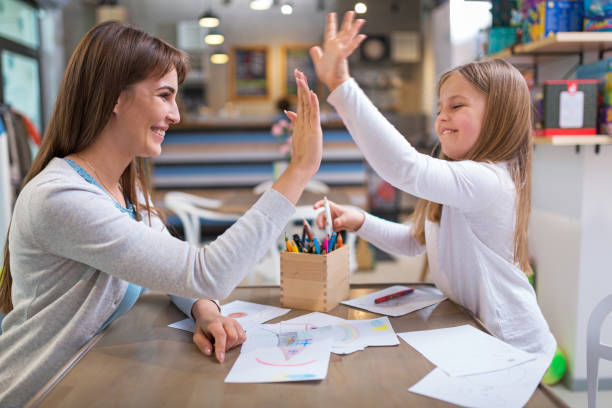 Mother and daughter drawing Mother and daughter having good time, smiling homework paper stock pictures, royalty-free photos & images