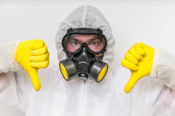 istock Man in coveralls with gas mask is showing negative gesture 683593534