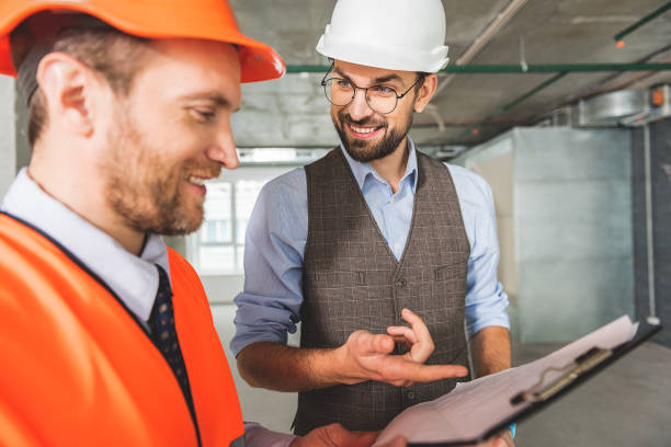 istock Hilarious contractor standing beside colleague 683597084