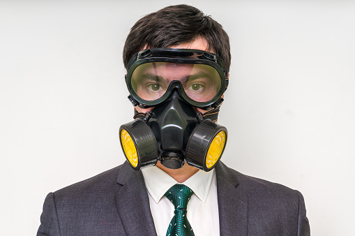 Young businessman with gas mask isolated on white