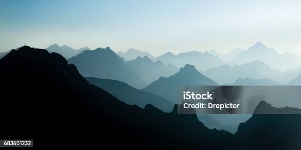 Spectacular Blue And Cyan Mountain Ranges Silhouettes Summit Crosses Visible Stock Photo - Download Image Now