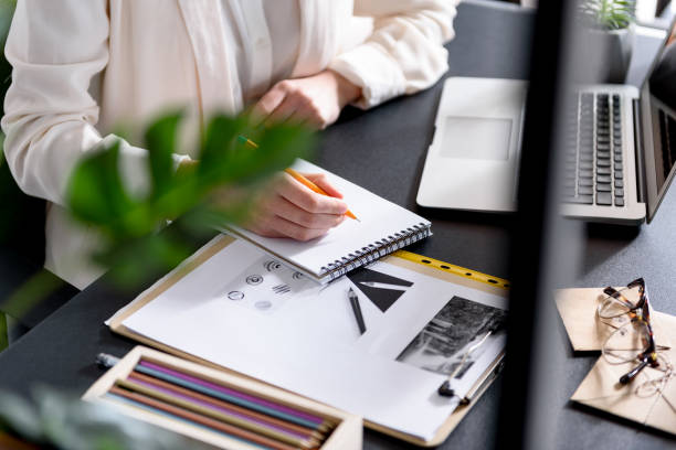 istock Youthful lady recording something in her copybook 683601358