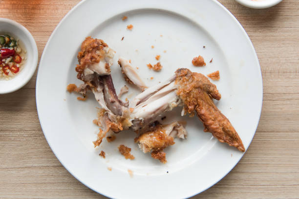 Chicken bone on a white plate wooden background