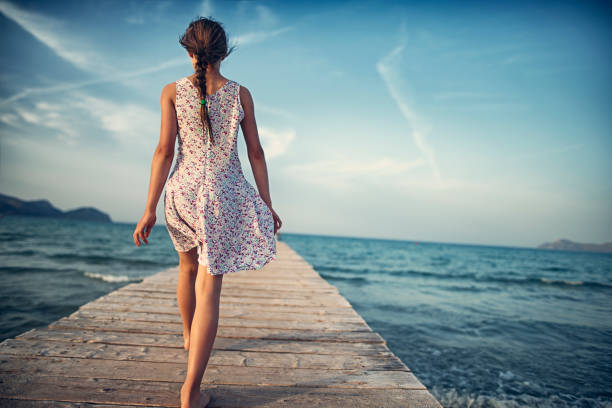 девочка-подросток, идущая по морскому пирсу - walking girl стоковые фото и изображения