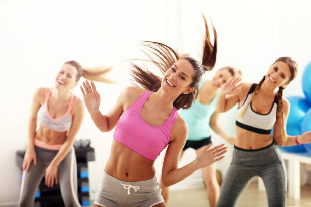 Group of happy people with coach dancing in gym stock photo