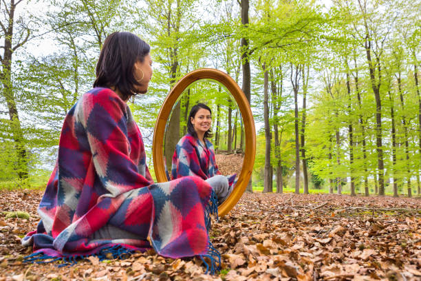 istock Woman sits with mirror in forest during spring 683646460